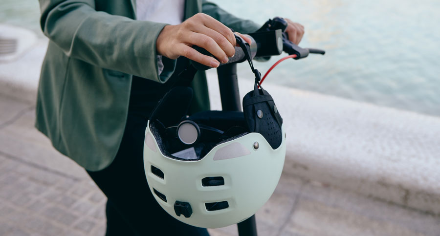 woman holding electric scooter with helmet