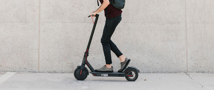 Sideways man riding e-scooter